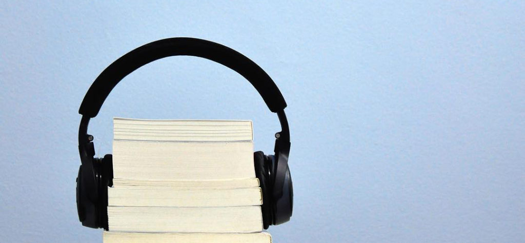 Picture of a stack of books with a pair of headphones around them.